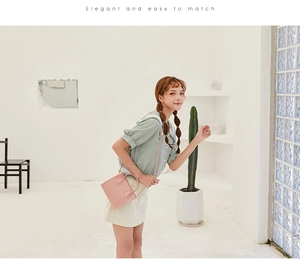 Pink croc-embossed small handbag with elegant shoulder strap shown on a female model