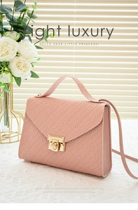 Detailed close-up of pink woven crossbody bag with elegant gold metal lock clasp