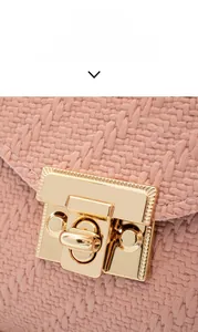 Close-up of pink woven texture material and golden metal push lock on square bag