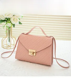 Detail view of the pink woven texture handbag with a golden clasp and envelope flap