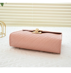 Close-up of pink woven texture handbag featuring a sophisticated gold twist lock buckle
