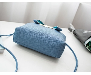 Dettaglio della borsa in pelle azzurra con motivo litchi e fibbia a fiocco dorata