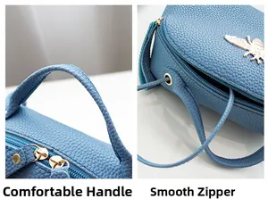 Detalle de bolso azul en cuero granulado con logo de abeja dorada y cremallera suave