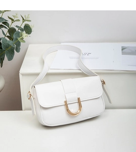 Primer plano del bolso de hombro blanco minimalista con hebilla en U dorada elegante