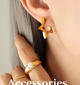 Detailed view of golden star earring and pearl ring set on model in elegant style