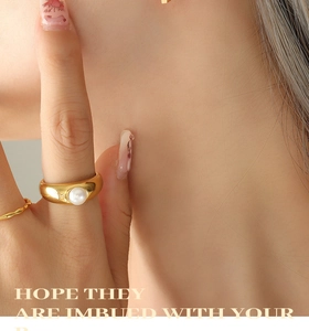 Macro shot of gold wide band ring with pearl and matching rope ring for women