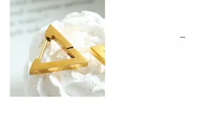 Macro shot of geometric gold triangle stud earrings made of high-quality stainless steel