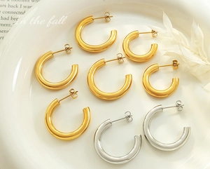 Detailansicht verschiedener klobiger C-Form Creolen in poliertem Gold und Silber Finish