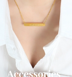 Détail du collier avec pendentif barre dorée gravé Good Luck porté par un mannequin
