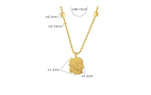 Detail of irregular gold pendant with Good Luck engraving and smile face on bead chain
