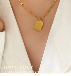 Macro view of 18K gold-plated necklace with a brushed finish Good Luck pendant