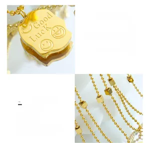 Macro detail of 18K gold plated square pendant with Good Luck engraving and smile faces