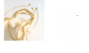 Detailed close-up of layered gold chains on white coral including Figaro and bead styles
