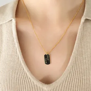 Goldene Kugelkette mit schwarzem Good Luck Anhänger, getragen von einem Modell