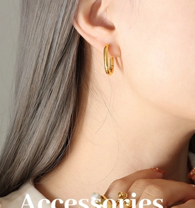Gros plan de boucles d'oreilles en U dorées minimalistes avec finition polie sur un mannequin