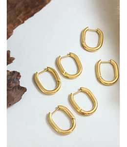 Détail macro de boucles d'oreilles en U plaquées or 18K poli sur fond blanc