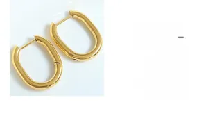 Gros plan de boucles d'oreilles huggie en U plaquées or 18 carats au fini poli minimaliste