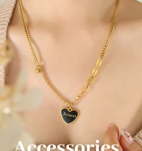 Close-up of gold layered heart necklace with black enamel Forever charm on a model