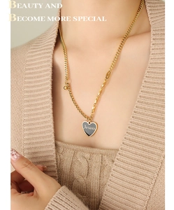Detail of gold heart pendant with black enamel and Forever engraving on chunky chain