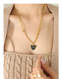 Detail of gold heart pendant with Forever engraving on a layered chain necklace