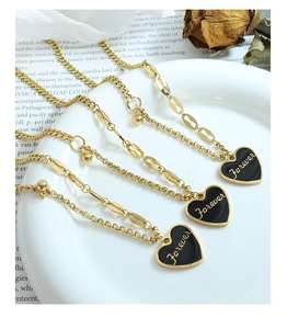 Detailed view of a gold heart pendant with 'Forever' engraving on a ceramic plate