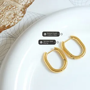 Boucles d'oreilles en U en acier titane plaqué or 18K sur plateau en céramique blanche