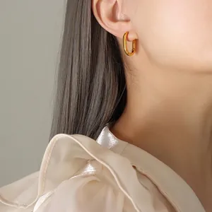 Boucles d'oreilles géométriques en U en acier titane plaqué or 18K sur modèle