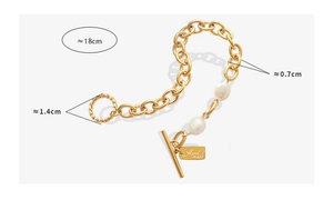 Detail of OT toggle clasp and baroque pearls on a gold-tone geometric chain bracelet