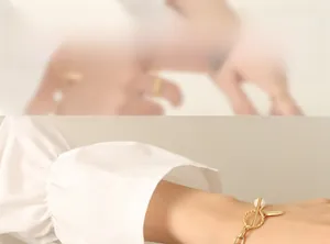 Detail of golden bracelet with OT toggle clasp, freshwater pearl, and rectangle charm