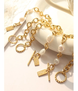 Detail of gold chain bracelet with freshwater pearls, OT toggle clasp, and handmade tag