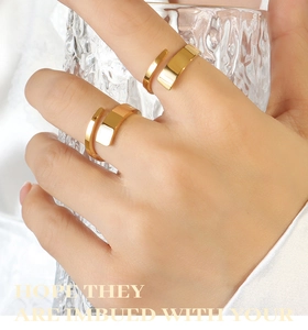 Detailed view of two minimalist 18K gold plated wide band rings with a polished mirror finish