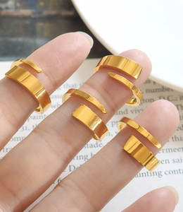 Macro view of gold plated spiral rings set with high-polished minimalist metal finish