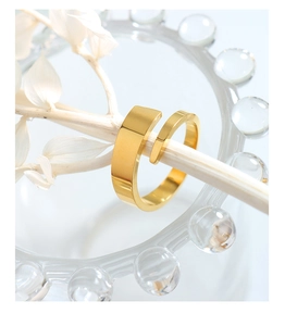Minimalist double-layered gold spiral ring displayed on a white twig branch