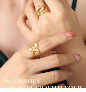 Close-up of dual gold-plated chunky chain rings on a hand with a minimalist hip-hop style