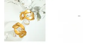 Close-up of gold plated stainless steel curb link chain ring on glass texture