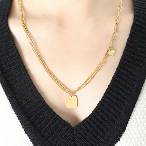 Double chain necklace with gold heart and rectangle pendant on black V-neck top