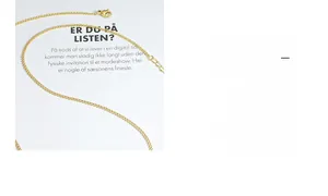 Détail d'un collier chaîne gourmette dorée avec fermoir mousqueton et extension réglable