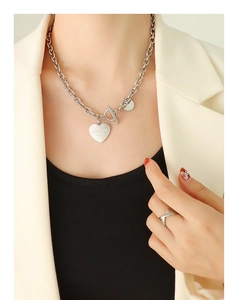 Vue détaillée du collier à grosse chaîne avec pendentif cœur et fermoir OT sur modèle