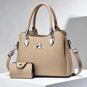Detail view of beige lychee texture boston handbag set with matching mini wallet and strap