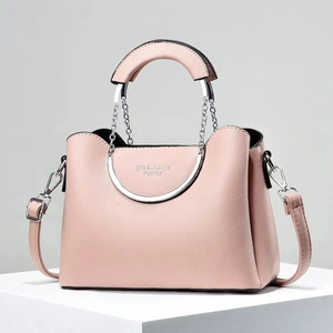 Detail of pink pebbled leather bag featuring circular silver metal handles and gold logo