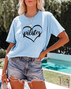 Close-up of the Pilates heart print and soft cotton fabric on a light blue summer tee