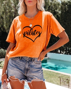 Close-up of orange Pilates heart t-shirt fabric texture and premium print detail