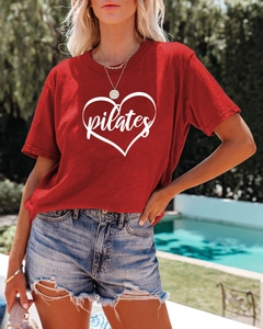 Detail of red Pilates T-shirt with heart print and distressed denim shorts by the pool