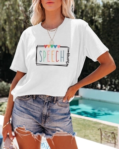 Détail du t-shirt blanc en coton avec imprimé et du short en jean déchiré en plein air