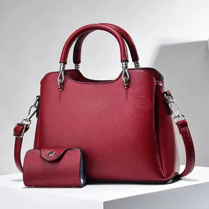 Detail view of burgundy pebble leather tote set with matching coin purse and silver hardware