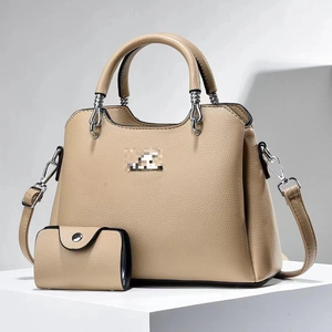 Detail of apricot pebbled leather handbag set with round silver handles and mini pouch