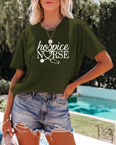 Détail de l'imprimé blanc Hospice Nurse et du stéthoscope coeur sur un t-shirt vert