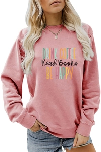 Detail of pink long sleeve sweatshirt featuring Drink Coffee Read Books Be Happy print