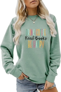 Close-up of sage green sweatshirt with artistic Drink Coffee slogan and ribbed cuffs