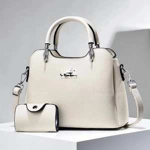 Detail of off-white lychee pattern leather tote bag set with silver hardware and shoulder strap